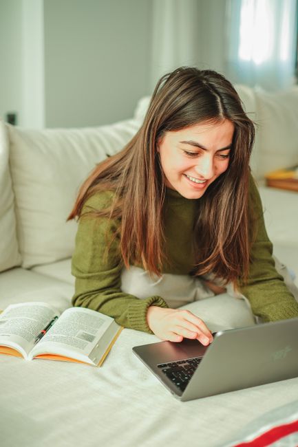 Laptop mit geöffneter Sprachlernplattform und Kopfhörern auf einem Schreibtisch